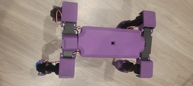 Top-down view of the all-purple next-revision Dog v3 chassis on the workshop floor